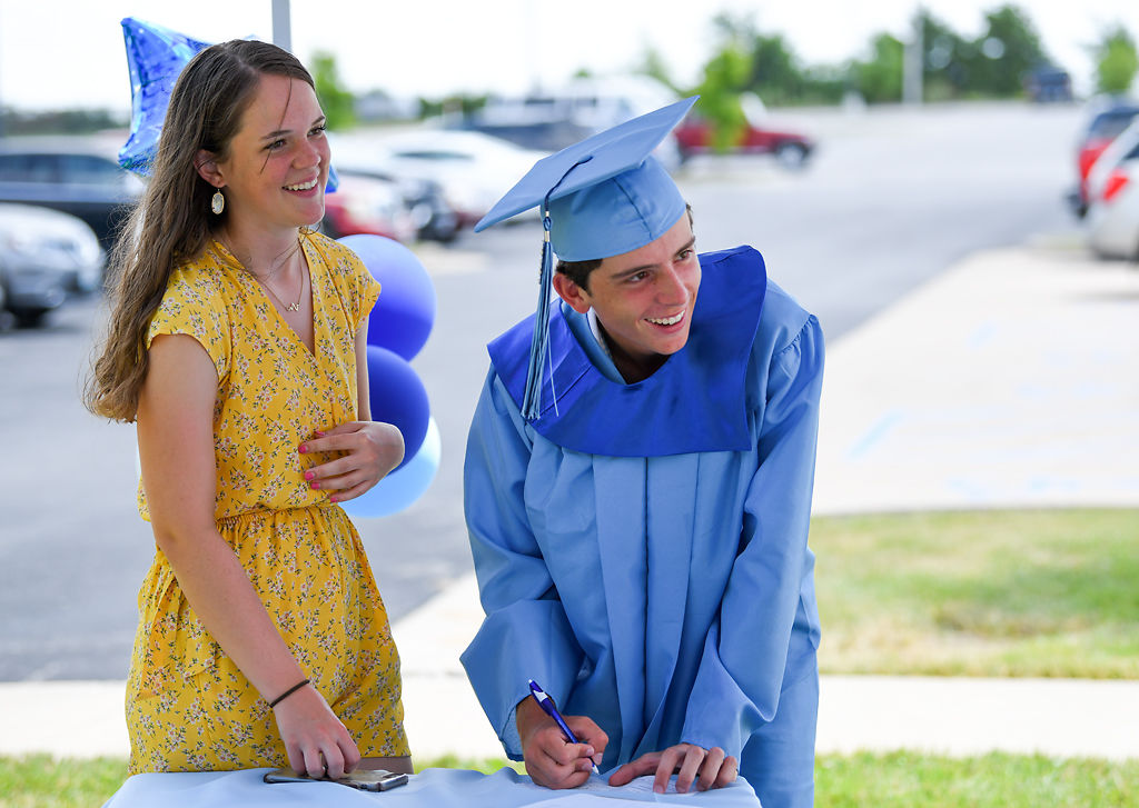 Jayden Berrey, 17, and graduating senior Joseph Fallis, check in for the graduation celebration